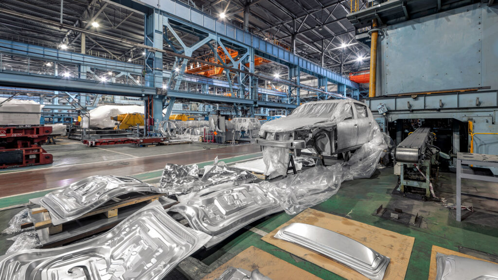 Automotive featured image showing car in factory ready for assembly with metal stamped door shells