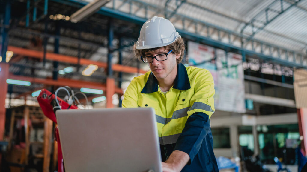 Order Management featured image with factory worker reviewing order details on a laptop on factory shop floor