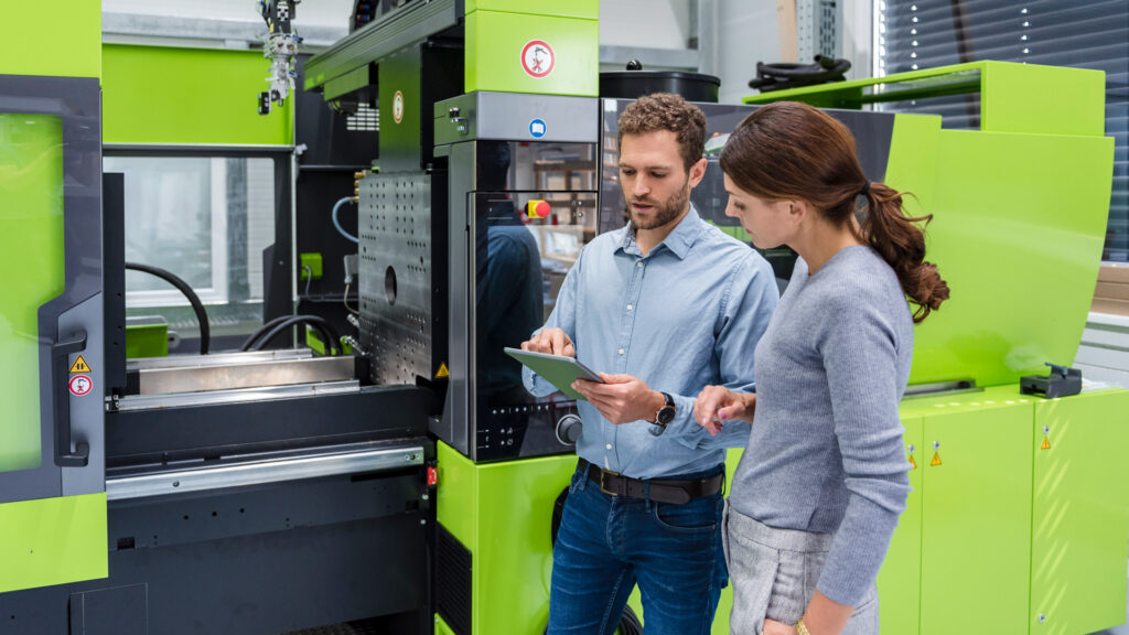 Plastics Manufacturing featured image showing two workers stood next to plastic injection moulding machine