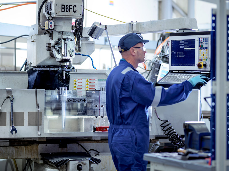 Factory worker shows the practical application of BOM in manufacturing using computer