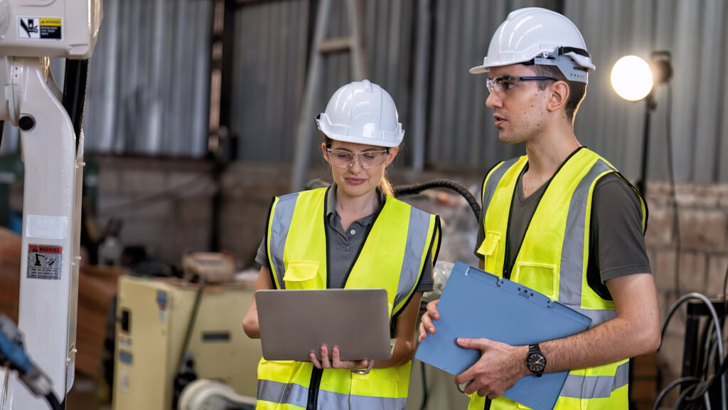 Male and female worker review scheduling and planning for factory shop floor