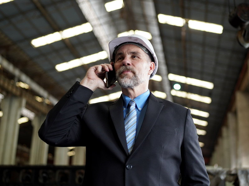 Male factory owner making a call on the phone to discuss standardisation across multiple factory sites